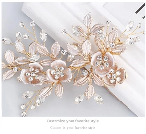 Macro shot of handcrafted bridal hair clip with gold alloy leaves and white enamel flowers
