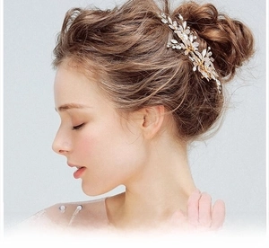 Close-up of a bridal gold leaf hair clip with crystals for elegant wedding styling