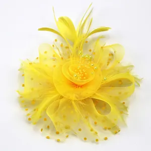 Détail d'un fascinateur jaune avec voile en résille, plumes et petites perles