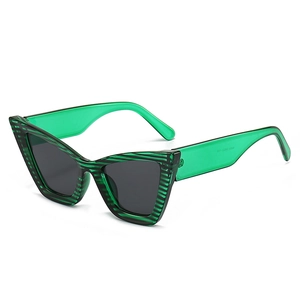 Fashion cat eye sunglasses with green striped frame and translucent temples in main view