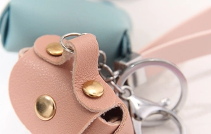 Macro shot of pink and mint green pebbled leather coin purses with golden rivet accents