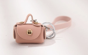 Detailed view of mini pink leather coin purse with metallic stud and silver keychain