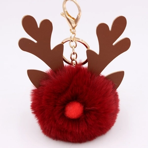 Close-up of deep red plush reindeer keychain with brown leather antlers and gold metal clasp