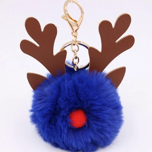 Detail of royal blue pompom reindeer keychain with brown antlers and gold metal clasp