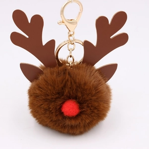 Close-up of brown plush reindeer pompom keychain with coffee antlers and gold clip