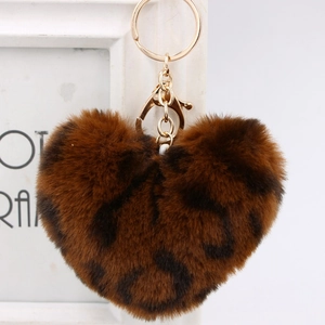 Macro detail of plush heart-shaped keychain featuring leopard print and gold hardware