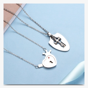 Detailed close-up of silver couples necklace set with heart lock and key charms