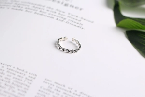 Close-up of S925 sterling silver ring with interconnected floral cross patterns