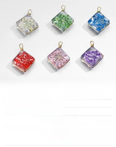 Close-up of dried flower glass pendants with eco-friendly copper gold-plated square frames