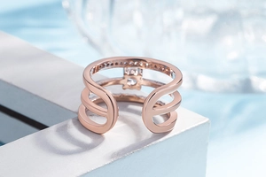 Close-up of rose gold multi-layer open ring with sparkling diamond accents on white texture