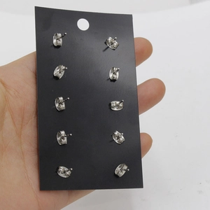 Cinq paires de boucles d'oreilles clous de 12mm en acier argenté sur une carte de présentation
