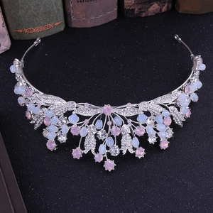 Detailed shot of silver bridal crown with pink rhinestones and leaf pattern on vintage books