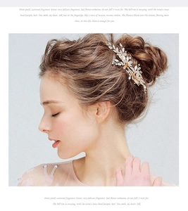 Detailed view of handmade gold wire hair clip with crystals and pearls on a bridal updo