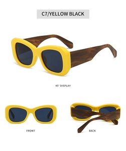 Detail view of yellow thick-frame sunglasses with dark lenses and faux bamboo patterned temples