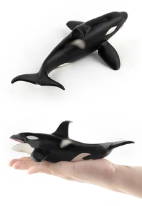 Macro detail of hand-held small realistic killer whale model with lifelike textures