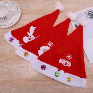 Close-up of three festive Christmas hats with reindeer, Santa, and snowman cartoon appliques