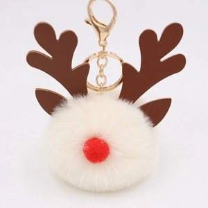 Close-up of white plush Christmas reindeer keychain with brown antlers and gold hook