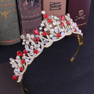 Macro detail of golden bridal crown featuring vibrant red teardrop gems and clear rhinestones