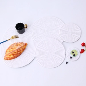 Detail view of various sizes of white woven cotton placemats in round and oval shapes