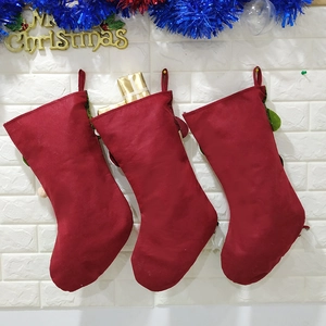 Detailed view of three red Christmas stockings hanging on a white brick wall for decoration