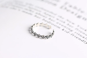 Detailed close-up of S925 sterling silver vintage cross open ring against a book background