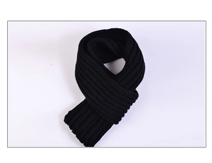Détail d'une écharpe en maille noire épaisse montrant la texture tricotée et le tissu doux