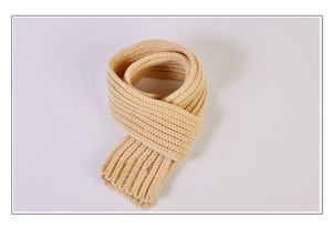 Gros plan sur l'écharpe en maille beige montrant la texture douce de la laine tressée