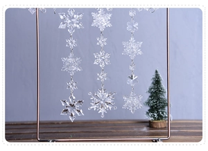 Close-up of hanging transparent acrylic snowflake ornaments with crystal beaded design