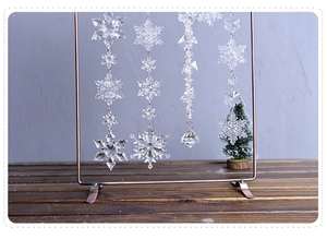 Close-up of clear acrylic snowflake ornaments and crystal beads hanging on a metal stand