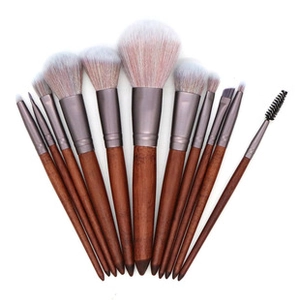 Macro shot of 11-piece brown wooden makeup brushes with pink and white gradient bristles