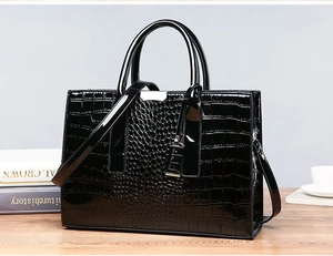 Detail of black crocodile texture handbag on wooden desk with professional business setting