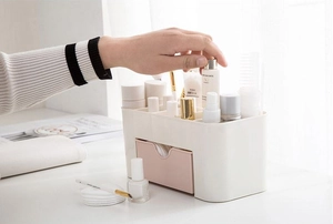 Detail of beige and pink drawer organizer for makeup and skincare on vanity desk