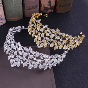 Sparkling silver and gold rhinestone leaf bridal crowns on vintage books background