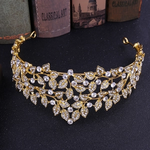 Close-up of golden leaf rhinestone bridal tiara resting on a vintage black surface