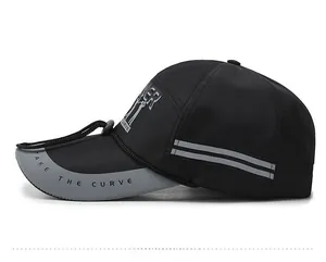 Side view of a black sports cap with reflective stripes and TAKE THE CURVE text