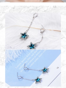 Detail shot of long star tassel earrings with blue pentagram stone and silver chain link