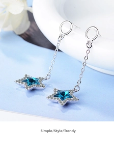 Macro detail of silver star earrings with blue gemstone and fine white crystals