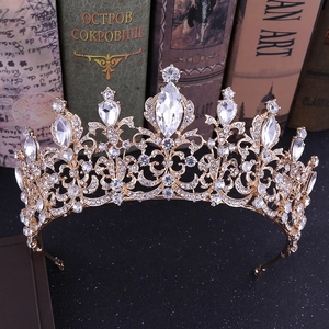 Baroque gold bridal crown with crystals on vintage books background for weddings
