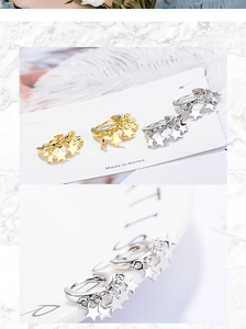 Close-up of gold and silver star charm earrings with polished finish on display card