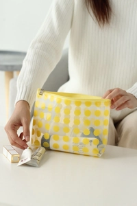 Macro shot of large yellow polka dots on a waterproof clear PVC cosmetic bag