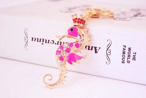 Close-up of seahorse keychain with pink enamel, red crown, and sparkling crystals