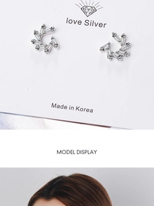 Detailed macro view of silver windmill earrings with sparkling rectangular zircon stones