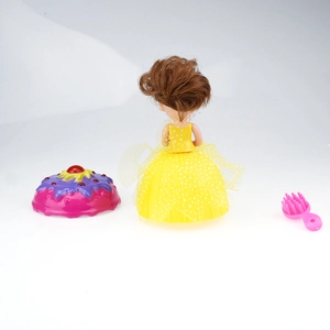 Detail of cupcake doll toy with yellow polka dot skirt and pink comb accessories