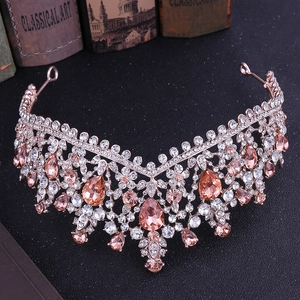 Macro detail of rose gold V-shaped bridal crown with peach teardrop crystals