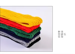 Gros plan de bonnets en grosse maille de diverses couleurs montrant la texture tissée