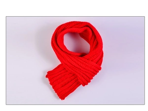 Détail de la texture d'une écharpe rouge en grosse maille pour enfants en laine