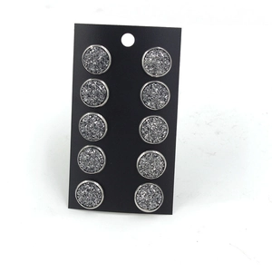Détail macro de douze paires de boucles d'oreilles rondes en titane gris foncé texturé
