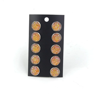 Détail de cinq paires de boucles d'oreilles 12mm argentées avec centres dorés scintillants