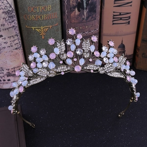 Vintage bronze leaf crown with pink and opal stones on rustic books background