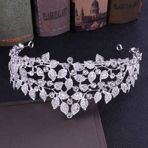 Close-up of silver crystal bridal crown with leaf patterns on vintage books